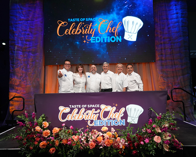 a group of people standing in front of a table with flowers