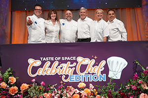 a group of people standing behind a table