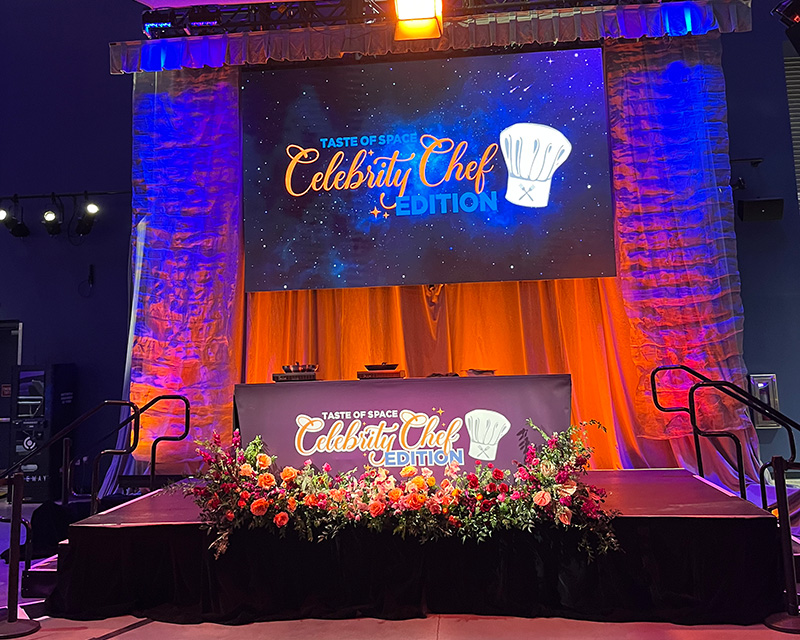a stage with flowers and a sign