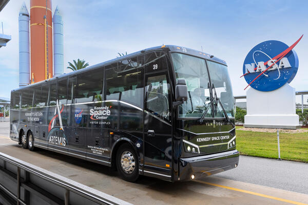 a black bus parked on the side of a road