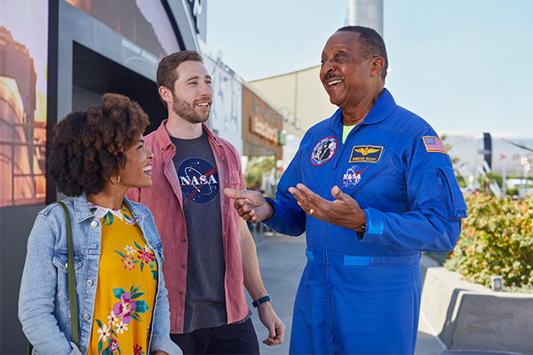 a man in a blue suit talking to a group of people
