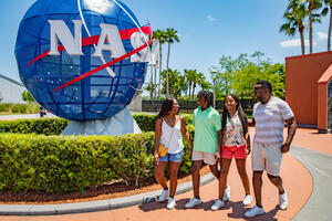 a group of people standing in front of a globe