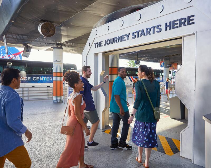 a group of people standing in front of a bus station