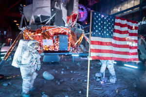 an astronaut standing next to a flag