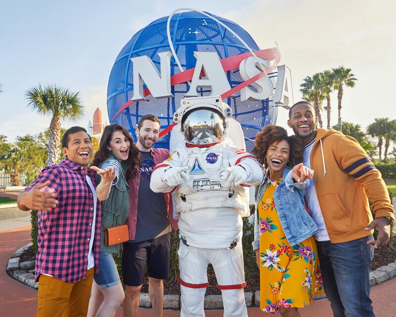 a group of people posing for a picture with a person in a space suit