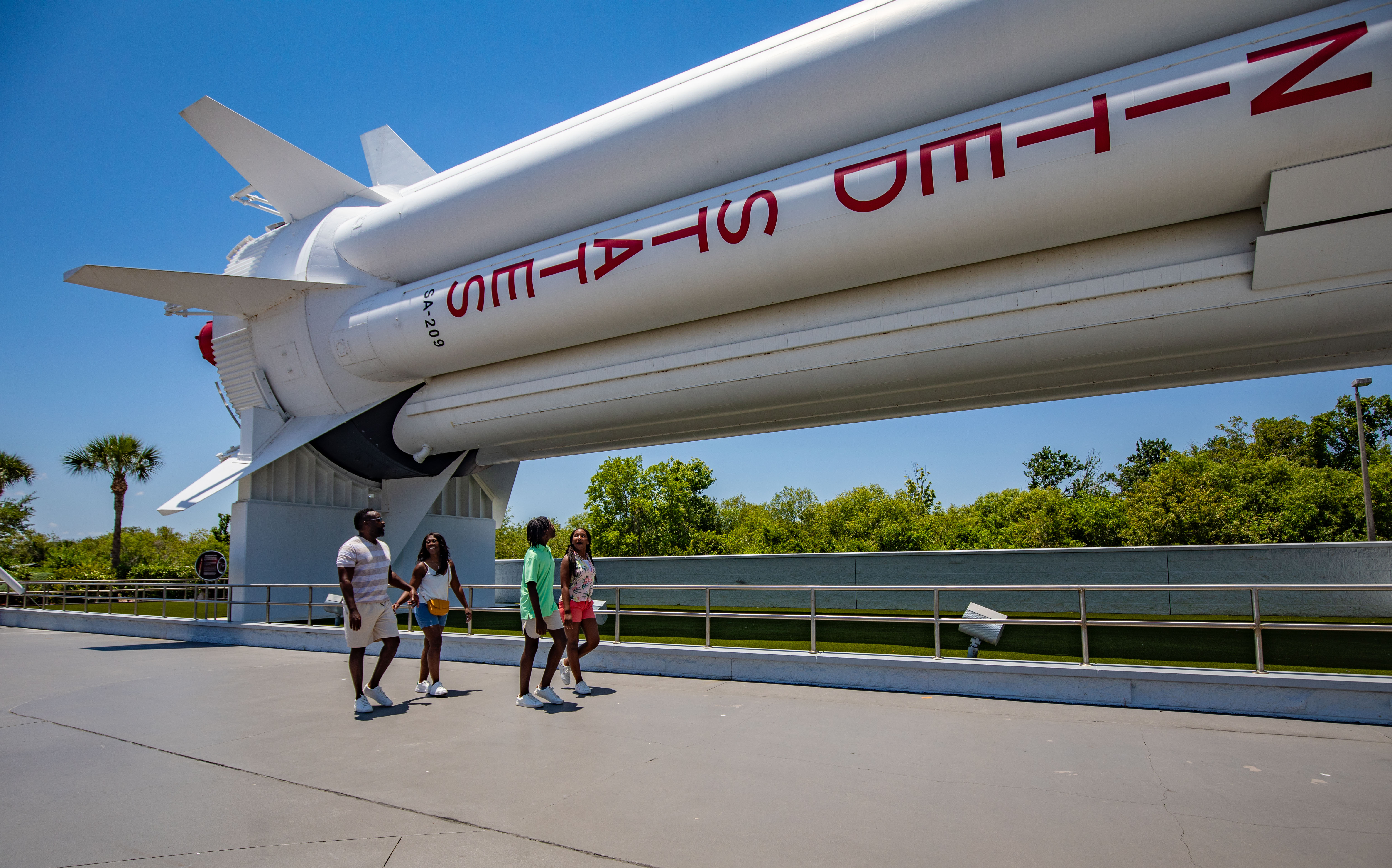 a group of people standing under a rocket