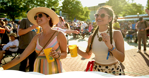 Two women look into the distance as they enjoy a summer festival in Louisiana.