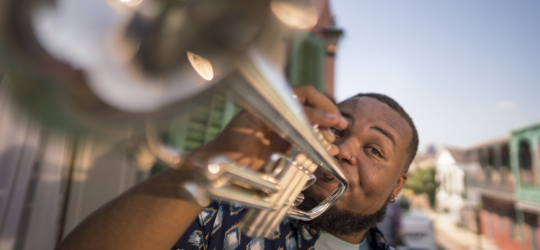 A close up image of a man playing a trumpet in the French Quarter.