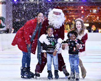 A family poses with Santa on the ice skating rink.