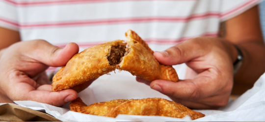 A man breaks apart a Natchitoches meat pie.