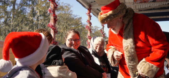 Santa greets a mother and her kids at a Christmas event in Houma.