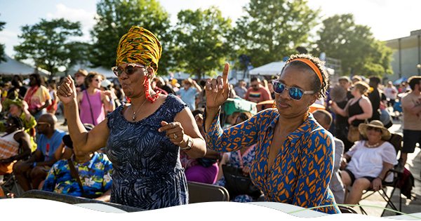 Two people dance at a music festival. 