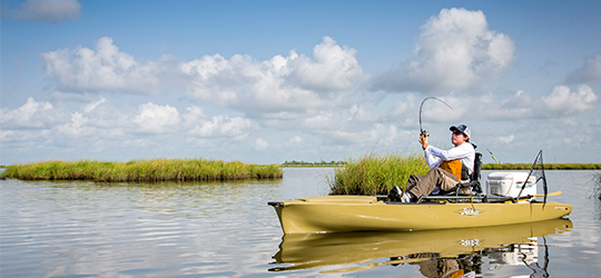 A fisherman casts a line from his kayak.