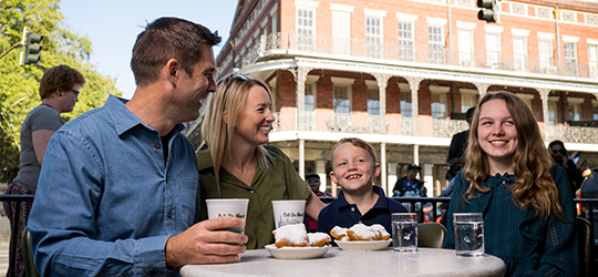 A family enjoys beignets together.