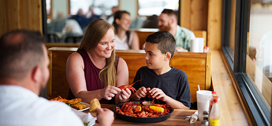 A family shares a platter of crawfish.