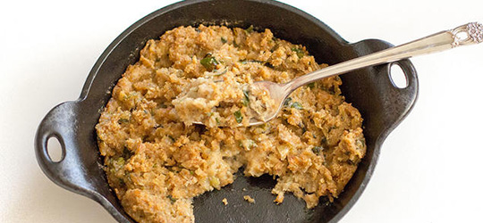 A cast iron skillet filled with moist oyster dressing.