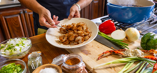A person prepares gumbo.
