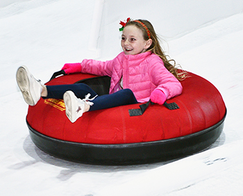 A child tubes at a Christmas festival.