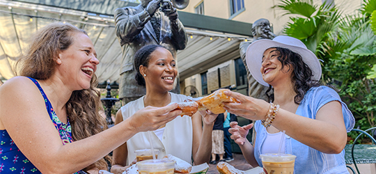 Friends share beignets at Music Legends Park.