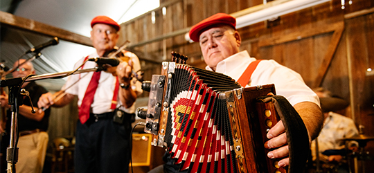A Cajun band member plays an accordion.
