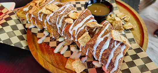 A plate of tender bread pudding served with a side of caramel.