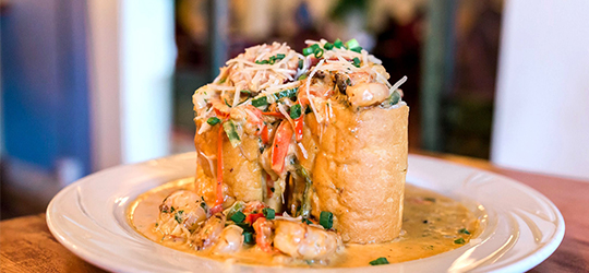 A dish of crawfish-stuffed French bread flecked with herbs and cheese.