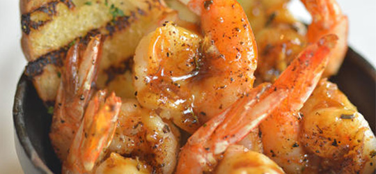A bowl of well-seasoned Louisiana barbecue shrimp.
