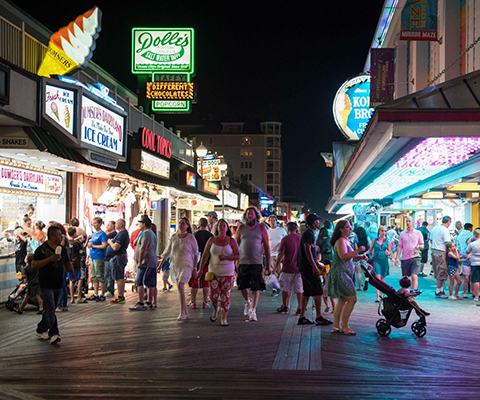 Picture of people walking and enjoying the Ocean City Boardwalk during the evening.