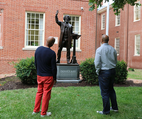 A picture of two gentlemen admiring a Frederick Douglass monument.