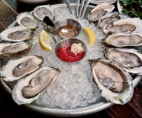 Picture of a ice covered platter of oysters on the half shell.
