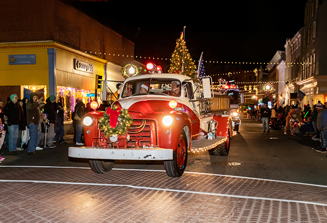 Picture of people admiring an antique fire truck going down Main Street for the holiday parade.