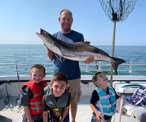 Man and three children on a fishing trip.