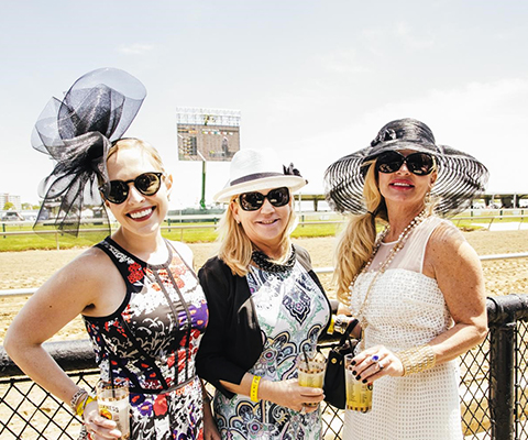 Three women attending the Preakness Stakes.
