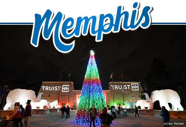 Festive Christmas tree with multicolored lights outside the gates of Memphis Zoo.