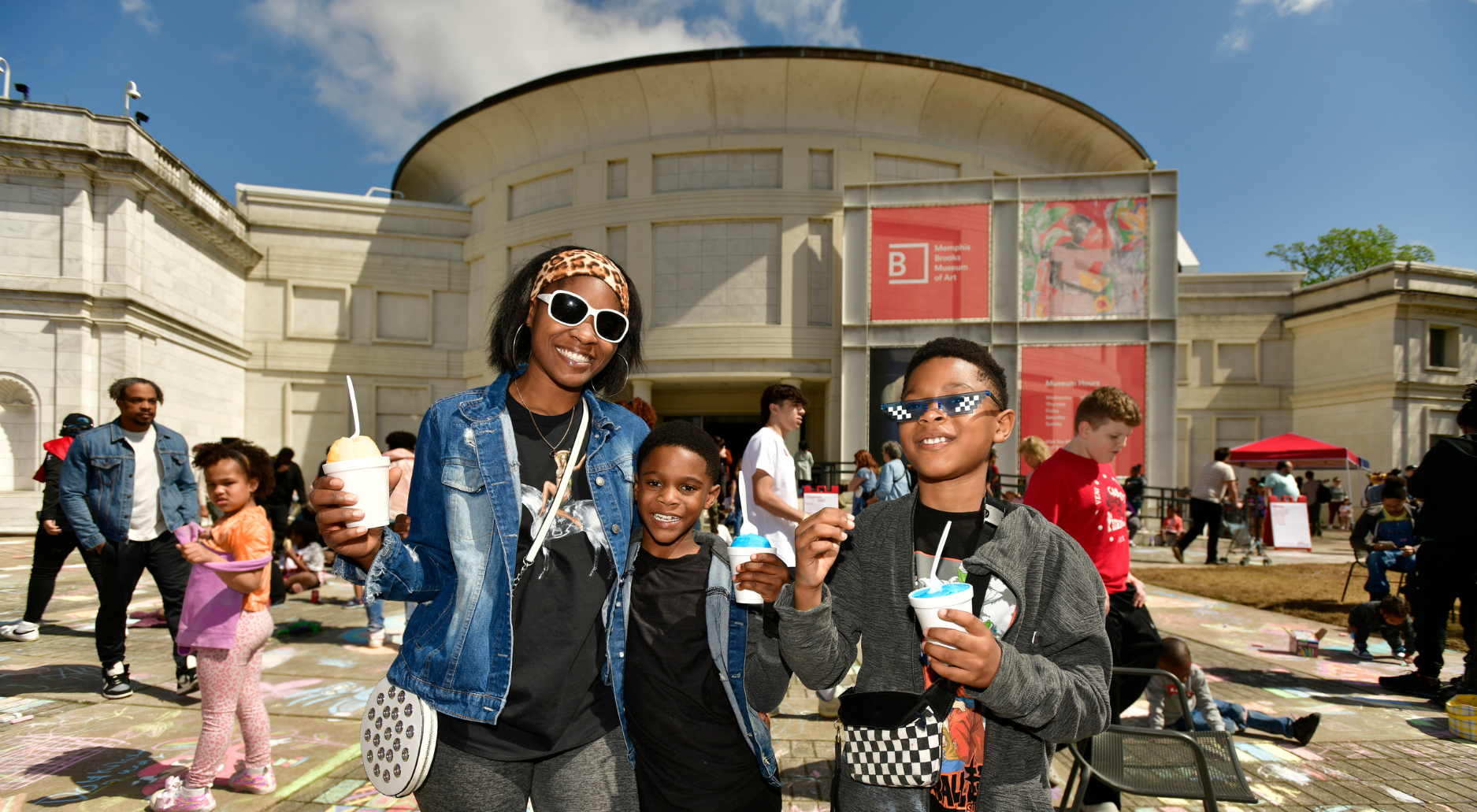 A family gathers on the outdoor plaza of the Memphis Brooks Museum of Art during a community event