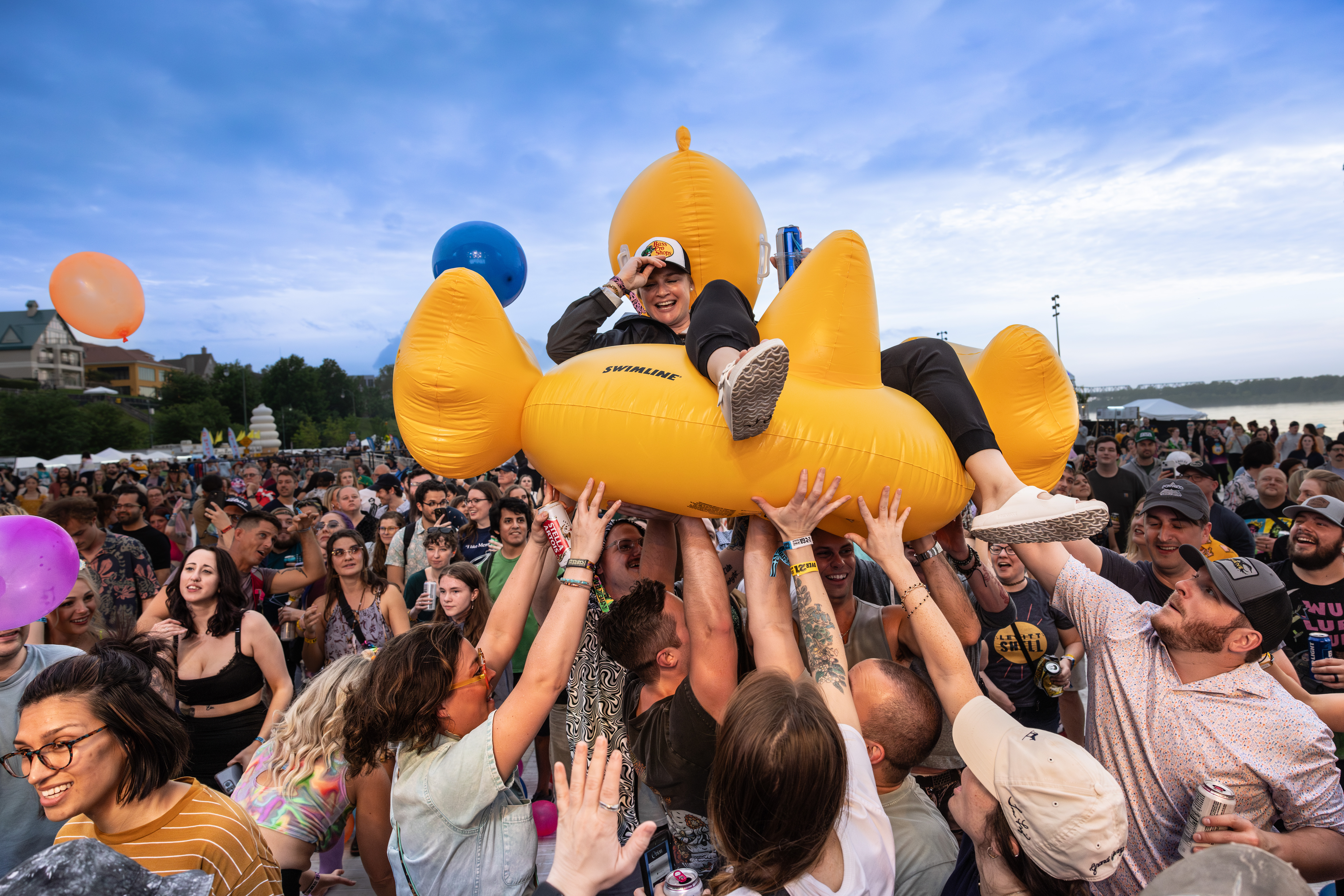 Someone crowd surfing atop an inflatable float at RiverBeat Music Festival.