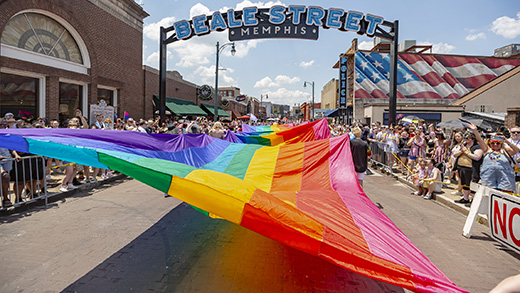 Crowds gathered on Beale Street watching a rainbow flag being stretched across the road during the Memphis Pride Parade.