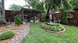 A Cooper-young home garden with a brick pathway as part of Experience Memphis Gardens.