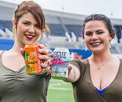Two people displaying craft beer cans at Memphis Brewfest.