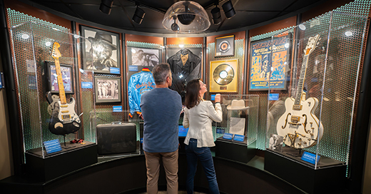A couple looking at an exhibit with records, photos and guitars at the Blue Foundation's Blues Hall of Fame.