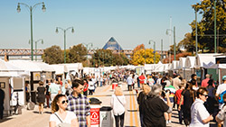 Festivalgoers exploring the booths at RiverArtsFest on Riverside Dr. 