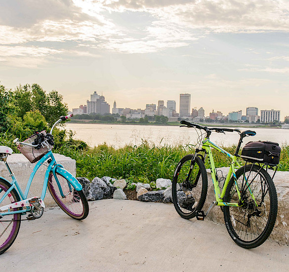 A view from West Memphis, Arkansas, with two bikes in the foreground with the Mississippi River and the Memphis skyline in the background.