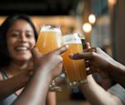 People touching glasses of beer together in a toast.
