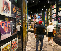 Visitors of the Stax Museum of American Soul Music walking through an exhibit showing the album covers of the studio's famed musicians.