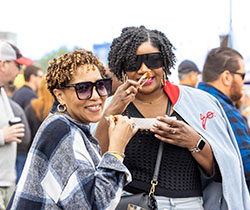 Two women enjoying wings at the World Championship Hot Wing Contest and Festival