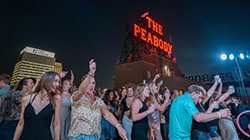 A group of people dancing under the red neon 