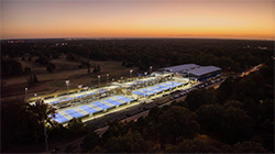 Aerial image of Leftwich Tennis Center showing multiple courts and indoor building lit up at night.