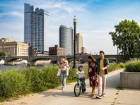 A family on a paved trail beside the Grand River in downtown Grand Rapids. 