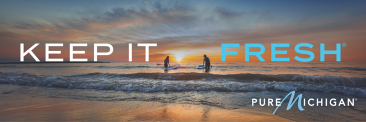 A billboard of surfers at sunset with overlaying text that reads "Keep It Fresh".