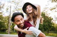 A man giving a woman a piggy back ride.